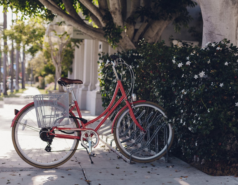 bici da città vicino alla boscaglia e all'edificio durante il giorno