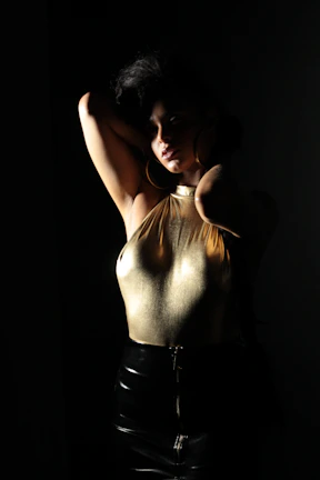 Close-up of Ania J’s fashion presence, showcasing intricate midnight black and gold couture under soft spotlight.