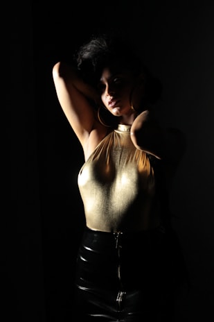 Model showcasing a sleek black faja with subtle gold accents in a softly lit boutique setting.