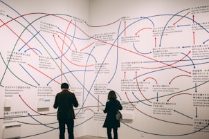 a couple of people standing in front of a wall