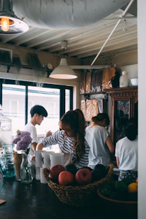Bright and airy common kitchen with guests cooking and sharing stories around the table