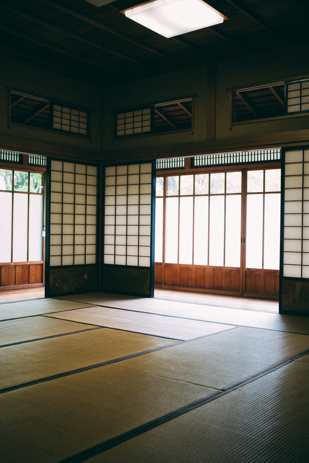 an empty room with tata mats and windows