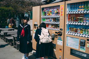 Students happily using Hydrofill stations outdoors surrounded by green campus trees