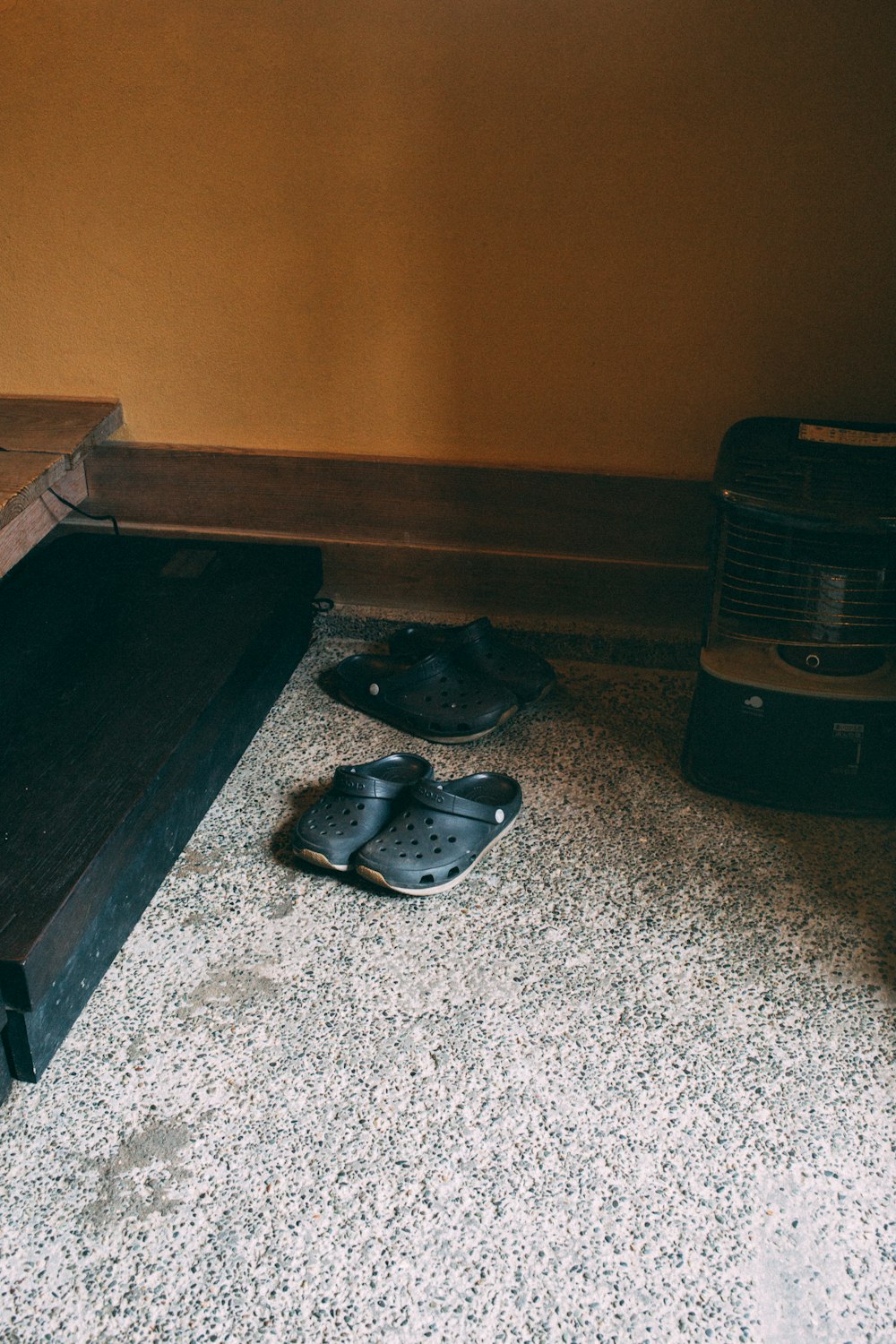 a pair of shoes sitting on the floor next to a heater