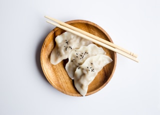 three white dimsum on brown bowl