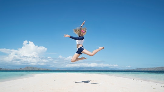 woman jumping with raising her right hand in Labuan Bajo Indonesia