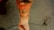 A forearm with intricate black and red tattoos featuring swirling patterns and designs, captured against a rough concrete surface with visible cracks.