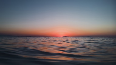 sunset in body of water