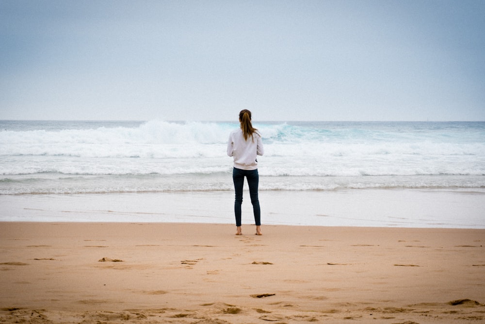昼間、海岸近くに立つ女性