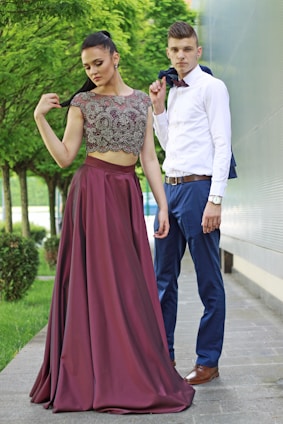 A stylish man and woman wearing elegant formal and casual outfits outdoors
