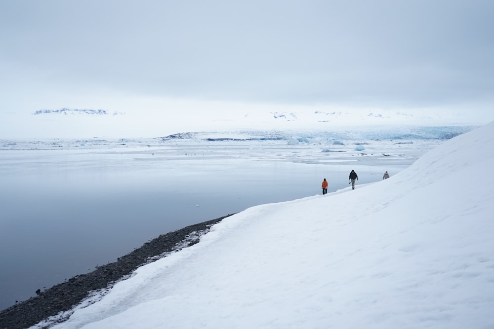 two people walking on snow covered ground