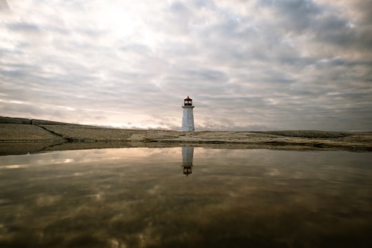 lighthouse reflecting on body of water in Peggys Cove Canada