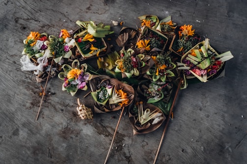 Close-up of a traditional offering bowl filled with flowers and coins.