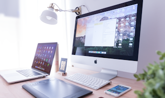 silver iMac near iPhone on brown wooden table