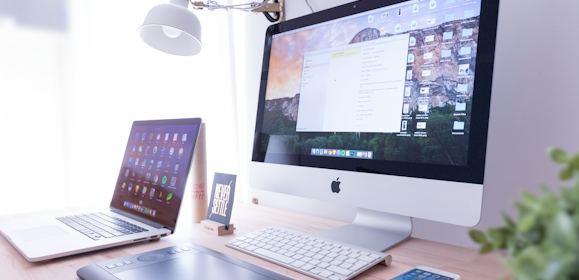 silver iMac near iPhone on brown wooden table