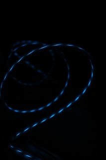 A glowing spiral of blue light against a dark background, creating a dynamic and mysterious visual effect.