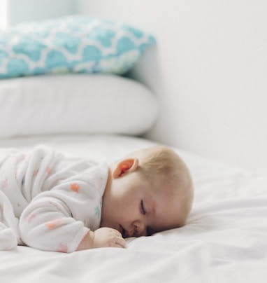 photo of baby laying on bed