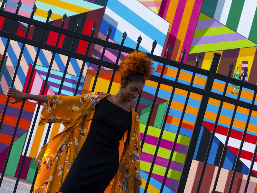 woman standing in front of black gate