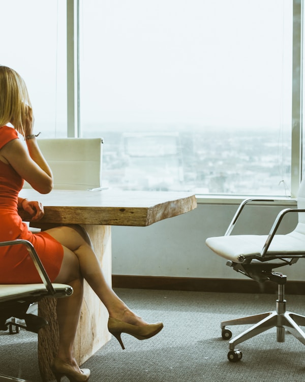 woman talking through mobile phone while sitting on swivel armchair