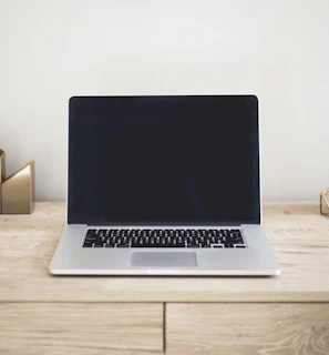 Minimalist Parisian-style workspace with sleek laptops and golden accents