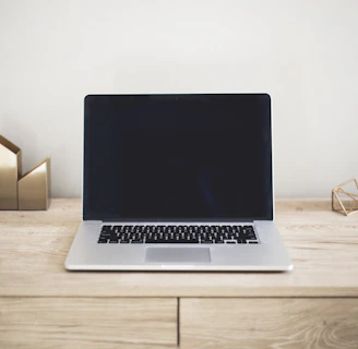 Minimalist Parisian-style workspace with sleek laptops and golden accents
