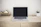 Elegant workspace with minimalist art prints hanging on a wall behind a laptop.