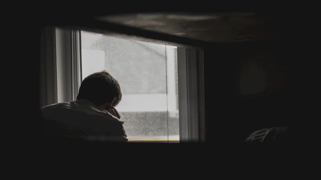 Hombre mirando hacia afuera por la ventana