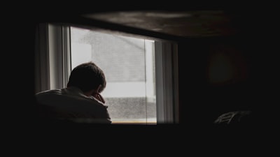 man looking outside by window sorrow google meet background