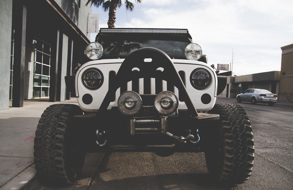 white Jeep Wrangler parked near building