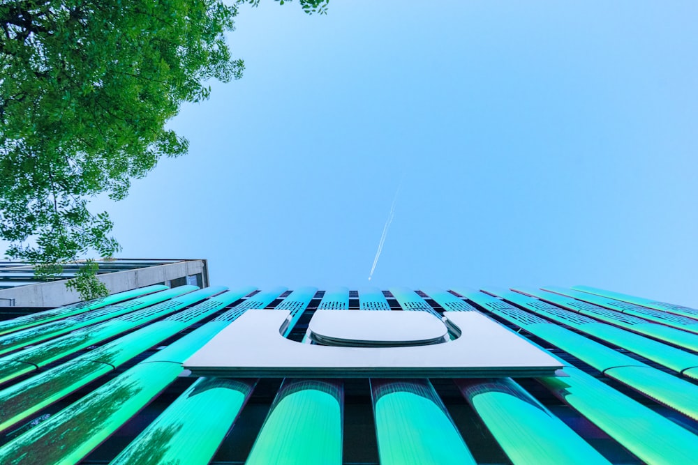 low angle photography of building under contrail