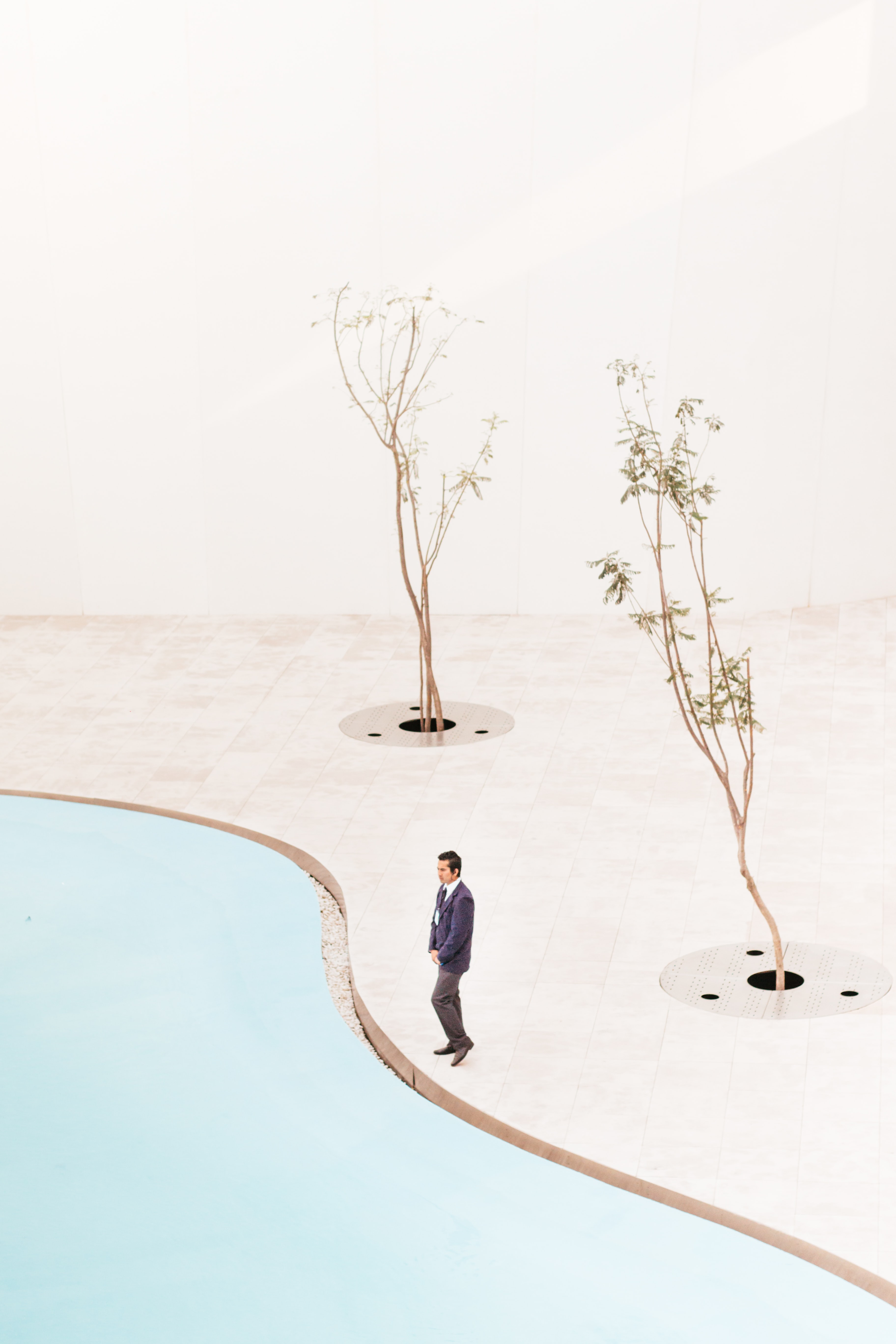 man standing near two trees at daytime