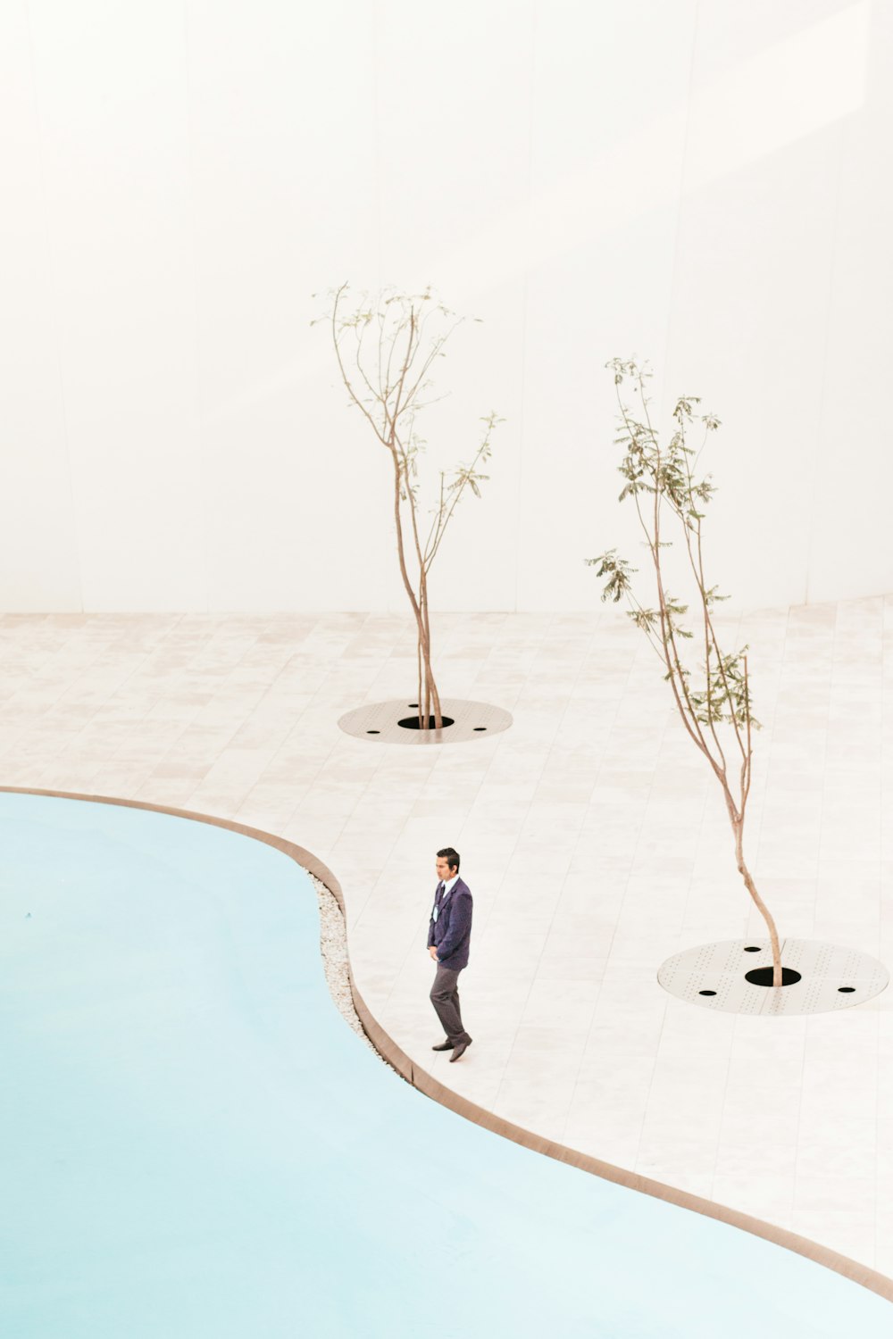 man standing near two trees at daytime