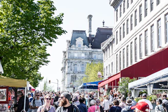 A bustling street scene in Edinburgh with historic buildings and lively market stalls.