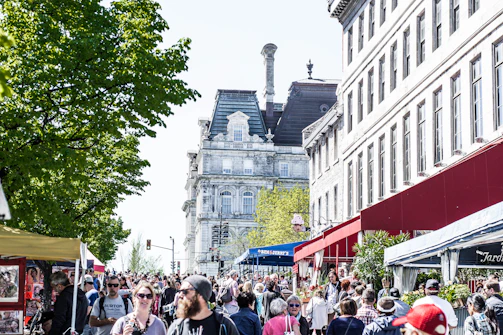 A bustling street scene in Edinburgh with historic buildings and lively market stalls.