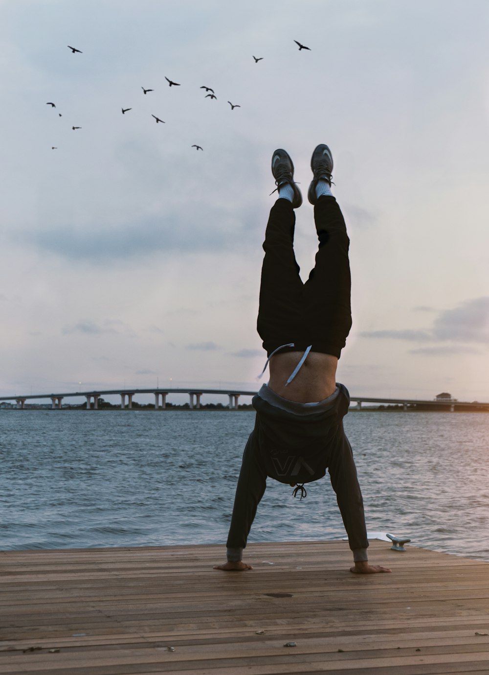 a person doing a handstand in front of a body of water