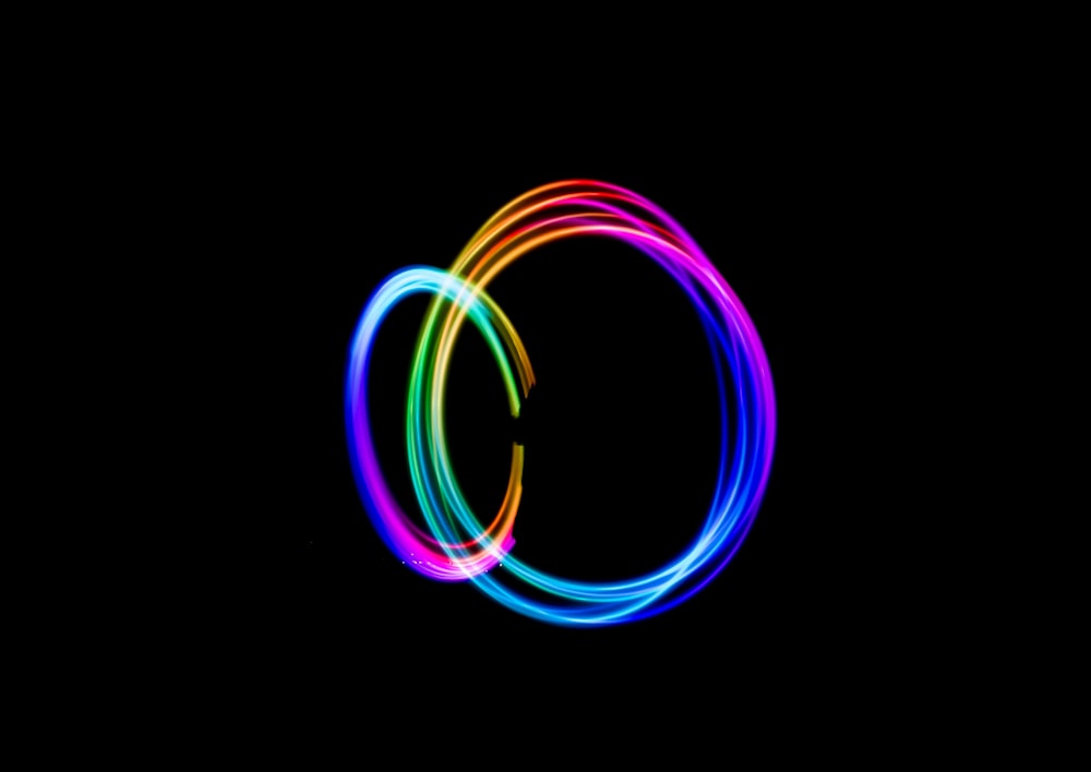 Fotografía de lapso de tiempo de una persona que hace un círculo de luz de arco iris