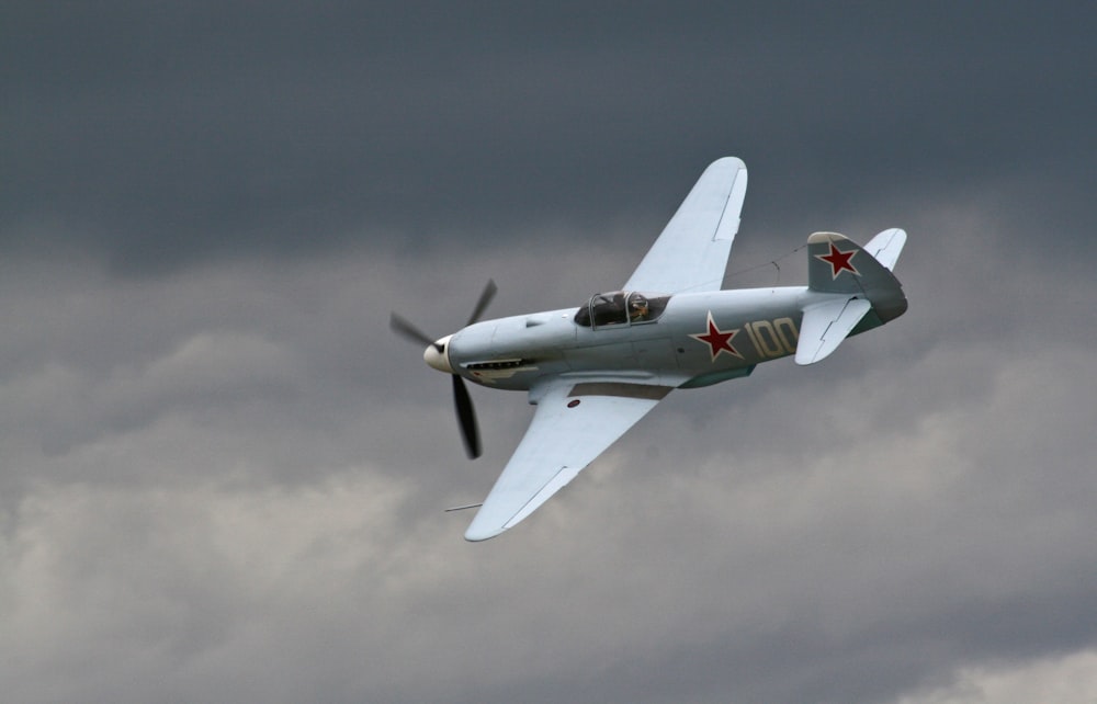 Grauer Doppeldecker unter grauen Wolken