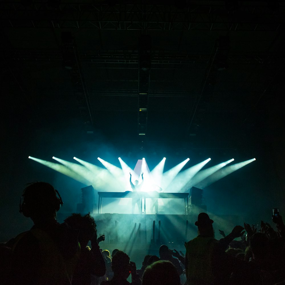 person standing under stage lights facing crowd