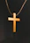 Close-up of hands holding a wooden cross pendant with soft natural light