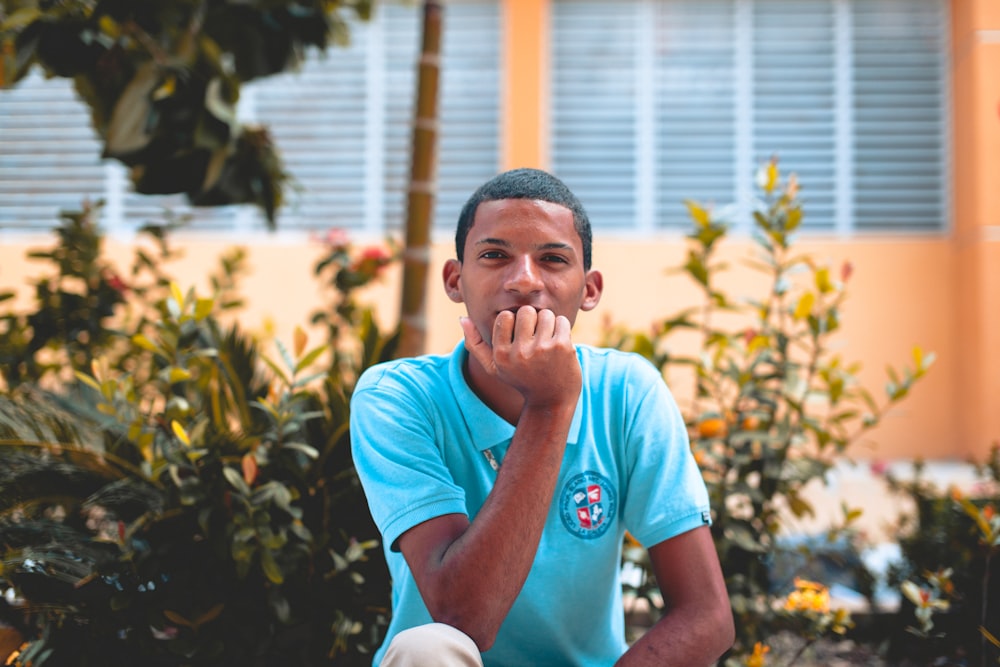 homme assis devant des plantes vertes pendant la journée