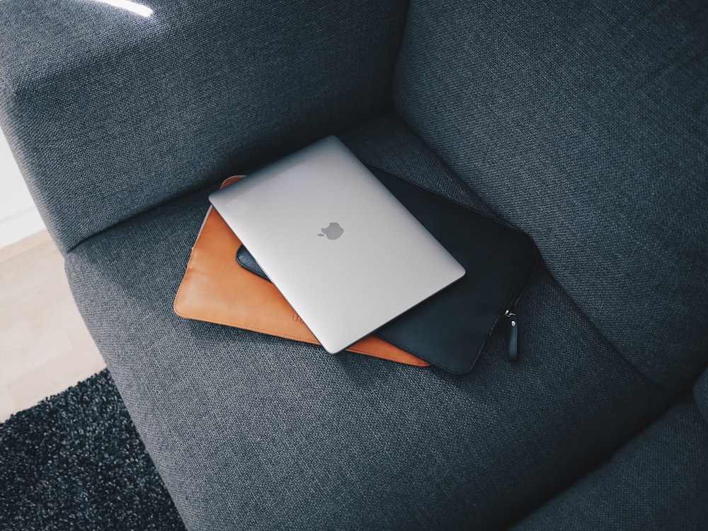 silver macbook on gray sofa