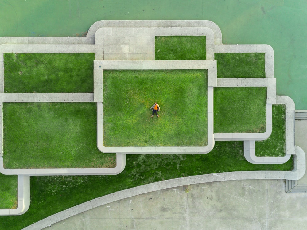 Foto aus der Vogelperspektive einer Person, die auf grünem Gras liegt