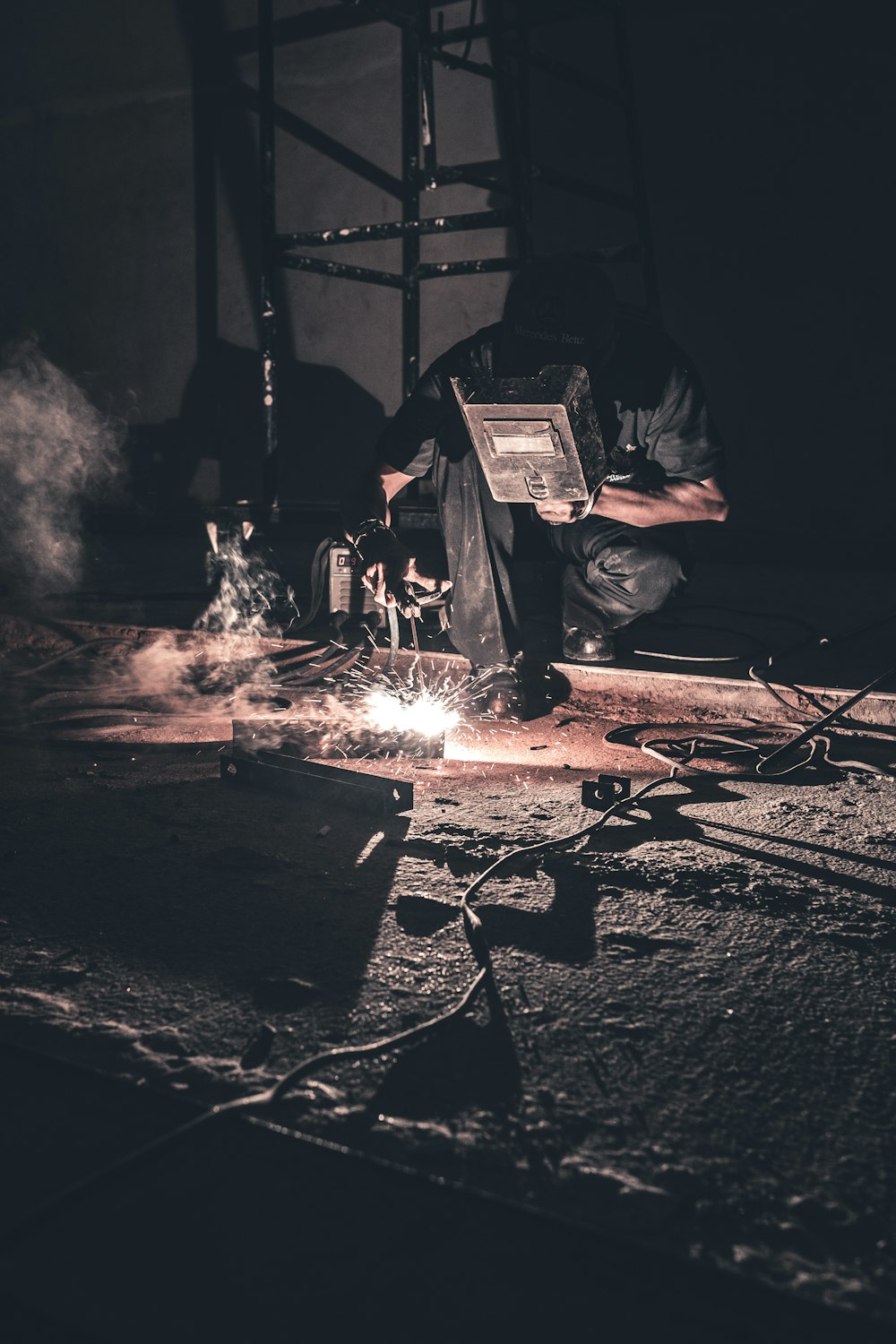 man welding black metal