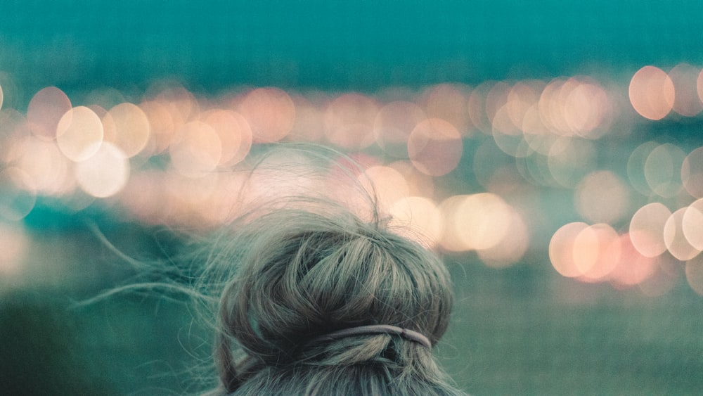 bokeh photography of blonde hair and orange lights