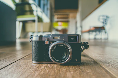 Close-up of a modern villa photo booth camera with a vintage lens on a wooden table.