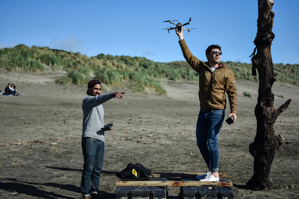 Gary and Rachel Morissey operating a drone camera on a scenic coastline at sunset.