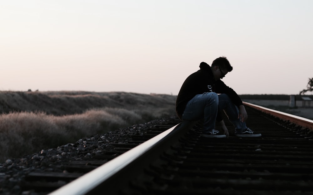 Mann sitzt auf der Eisenbahn