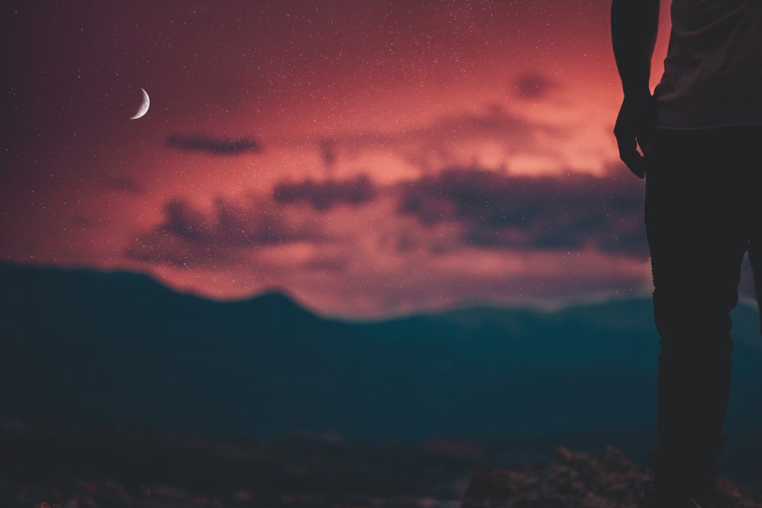 silhouette of man looking at moon,