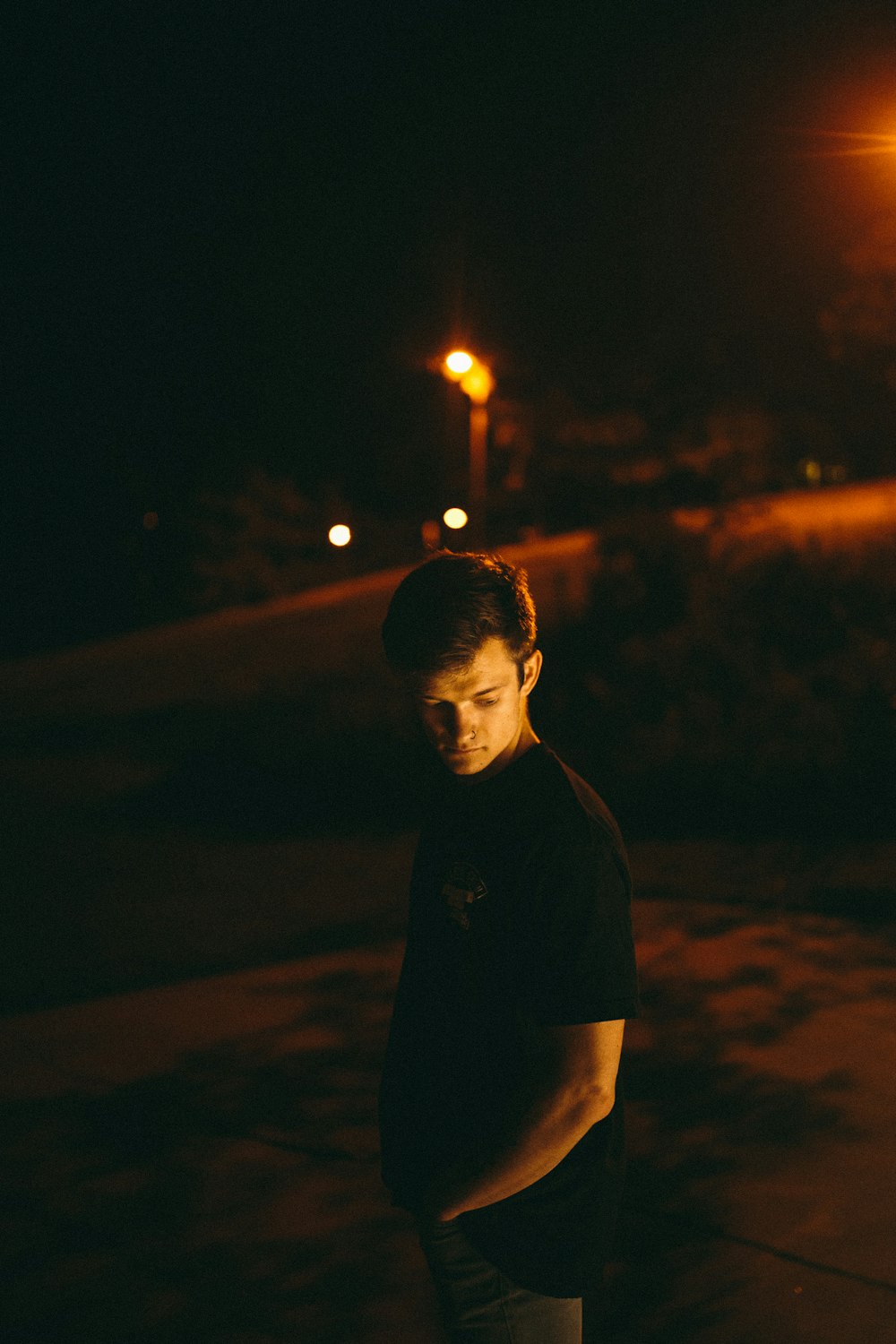 man in black polo shirt standing during night time