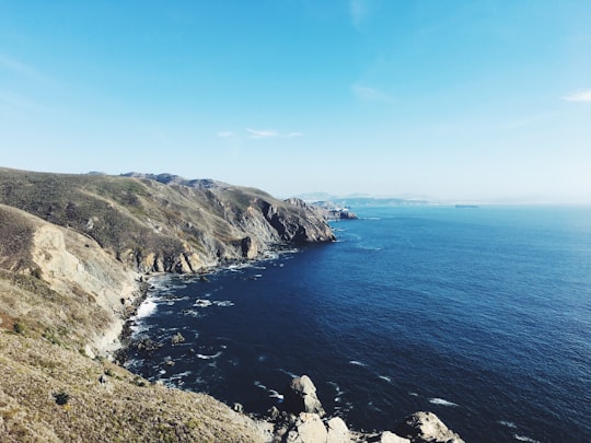 cliff beside ocean under clear blue sky during daytime in Golden Gate National Recreation Area United States